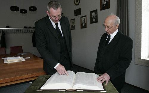 BARNEVELD â€“ Ds. C. Hogchem (l.), predikant van de gereformeerde gemeente te Barneveld, kreeg zaterdag uit handen van ds. P. Blok de eerste kanselbijbel van de GBS. De Bijbelstichting gaf het geschenk als dank voor het kosteloos beschikbaar stellen van h