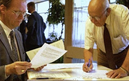 PUTTEN - Bezoekers van de jaarvergadering van de Gereformeerde Zendingsbond tekenden woensdagavond de presentielijst. - Foto Dick(Vos