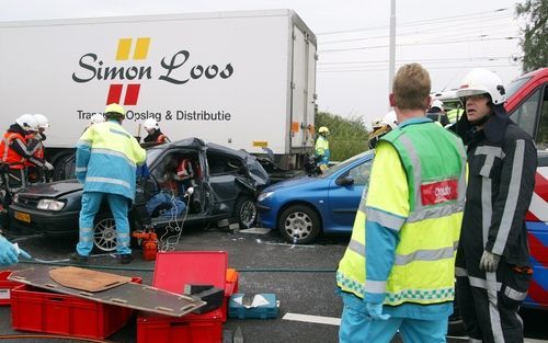 DEN HAAG - Reddingswerkers proberen een automobilist te bevrijden. Foto ANP