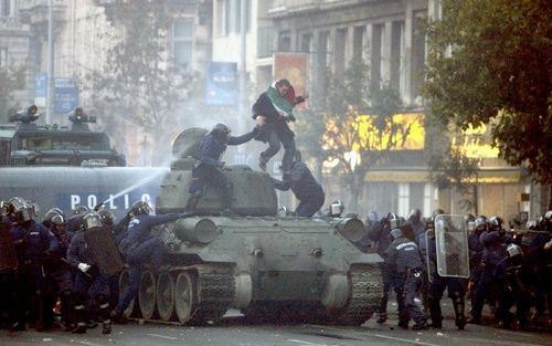 BOEDAPEST â€“ Agenten van de Hongaarse oproerpolitie proberen demonstranten te verjagen van een historische tank die maandag in Boedapest meereed in een parade ter gelegenheid van de herdenking van de Hongaarse opstand van 1956. Bij rellen tussen betogers