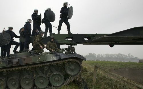 DOORNENBURG - ME-ers lopen dinsdag over een brug van de Genie naar Fort Pannerden. Krakers hadden de ophaalbrug van het fort gesloten. Daartoe werden bruggenlegende Leopard tanks ingezet. Veertig militairen van de landmacht waren opgeroepen om mee te help