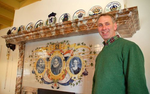 Boer en beheerder Herman Veltman toont het pronkstuk van het Oranjemuseum in Diepenheim. Op een tegeltableau van Makkummer aardewerk staan drie Oranjes: prins Willem van Oranje, prins Maurits en koningin Beatrix. Fotoâ€™s RD