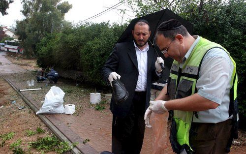 SDEROT – Een inwoner van het Israëlische Sderot overhandigt een schoen aan een orthodox-joodse man die woensdag in het stadje menselijke resten verzamelde, nadat daar een Qassamraket was geëxplodeerd. Bij de raketaanval vanuit de Gazastrook viel een dode 