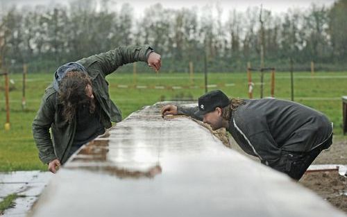 UTRECHT – De in 2003 opgegraven Romeinse boot De Meern 1 krijgt een reconstructie. Drie enorme boomstammen vormen de basis voor het schip. Leermeester Dimitri Marangos (l.) geeft aanwijzingen. Foto Erik Kottier.