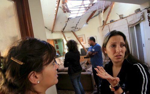 SDEROT – Israëli’s uit de stad Sderot in hun woonkamer, die zaterdag door een Qassamraket werd getroffen. Zondagochtend is een staakt het vuren ingegaan tussen Israël en Palestijnse gevechtsgroepen. Foto EPA