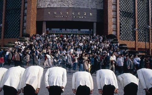 SEOUL - Bezoekers verlaten de grootste pinksterkerk ter wereld in Seoul. Koreaanse christenen kijken dezer dagen massaal naar de wedstrijden van het wereldkampioenschap voetbal. Tot in hun kerkgebouwen staan televisieschermen. - Foto RD