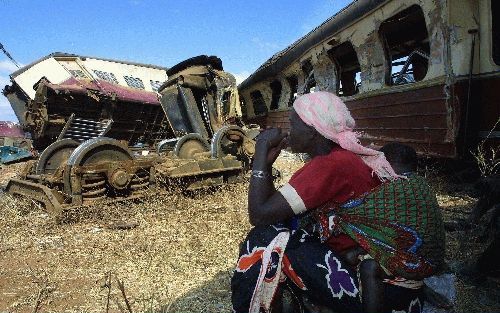 DODOMA - Een Tanzaniaanse vrouw kijkt naar de wrakstukken van de passagierstrein die maandagavond op een goederentrein botste. Het dodental van de ramp is inmiddels opgelopen tot 174. - Foto EPA