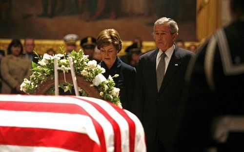 WASHINGTON - President Bush en zijn vrouw bij de kist met het lichaam van de Amerikaanse oud-president Ford. Foto EPA