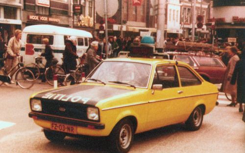 De politie Leeuwarden surveilleert met de geel oranje Escort uit 1980 op de hoek Nieuwestad en Wirdumerdijk. Foto FD, Northview