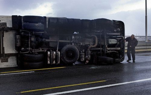 MOERDIJK – Op de Moerdijkbrug gingen donderdag door de zware zuidwesterstorm twee vrachtwagens op hun kant. Chauffeur Sigrid Can van transportbedrijf Langen uit Geleen kwam met de schrik vrij. „Je voelt de boel omslaan. Angstig, hoor.” Foto ANP