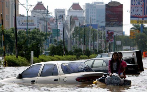 JAKARTA – Inwoners van Jakarta varen op een zelfgemaakt vlot door de straten van de Indonesische hoofdstad. Door nieuwe hoosbuiten zijn grote delen van Jakarta dinsdag opnieuw overstroomd. Het dodental als gevolg van de wateroverlast is inmiddels tot vijf