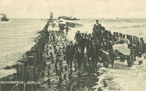 HOEK VAN HOLLAND – Met een bolderkar werden een eeuw geleden slachtoffers van de ramp met de Berlin afgevoerd. Op de achtergrond het wrak van het schip, dat in tweeën brak nadat het op de Noorderpier liep. Foto ANP