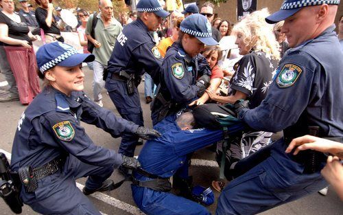 SYDNEY - De Australische politie pakt demonstranten op tijdens het bezoek van de Amerikaanse vice–president Cheney aan Sydney. Foto EPA