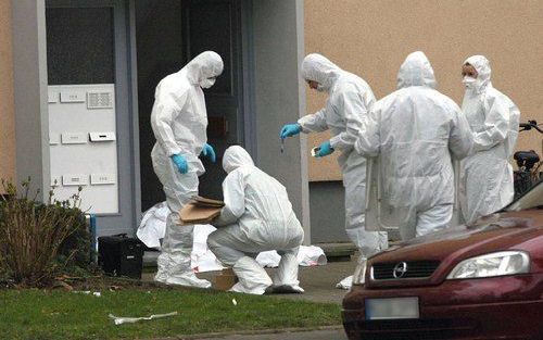 Politieagenten doen sporenonderzoek bij het stoffelijk overschot van een doodgeschoten vrouw in Mönchengladbach. Foto ANP