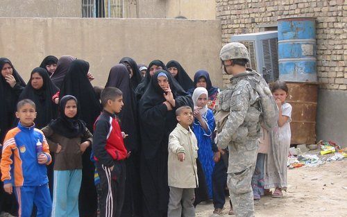 BAGDAD – Inwoners van Bagdad staan in de rij voor een school die door Amerikaanse militairen tijdelijk tot kliniek is omgevormd. De Iraakse bevolking is vier jaar na de Amerikaanse invasie steeds pessimistischer geworden. Slechts 18 procent heeft vertrouw