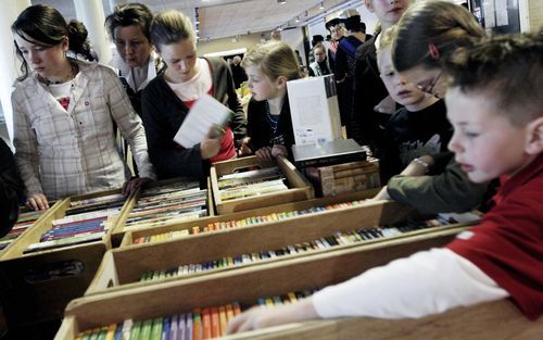 KAMPEN – Op de landelijke zendingsdag van de stichting Balkanzending neuzen kinderen met grote belangstelling tussen de jeugdboeken. Foto: Dick Vos