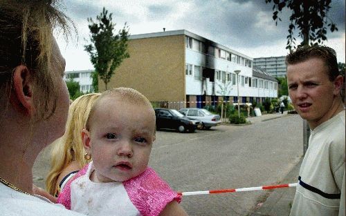 ROERMOND - Buurtbewoners kijken ontdaan naar het uitgebrande huis in de Jupiterstraat in Roermond. Bij het gezinsdrama kwamen zes jonge kinderen om het leven. - Foto RD,SjaakVerboom