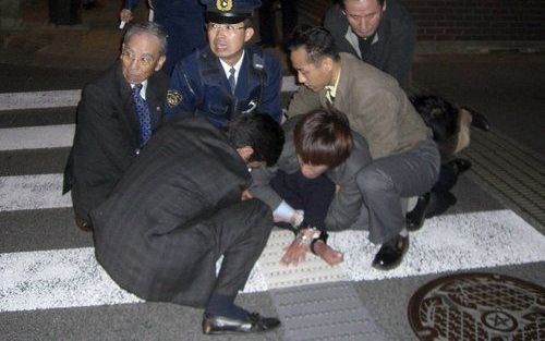 NAGASAKI - De Japanse politie arresteert de man die even daarvoor de burgemeester van Nagasaki doodschoot. Foto EPA