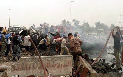 BAGDAD - Omstanders proberen slachtoffers van een autobom te redden in Bagdad, Irak. Foto EPA