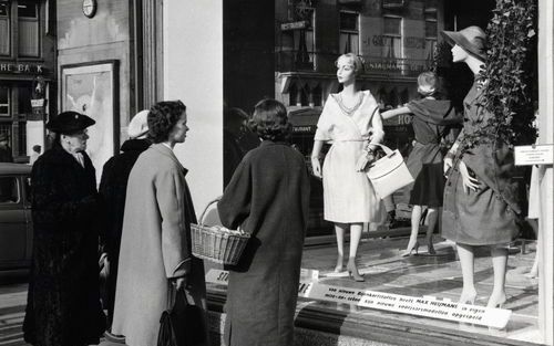 Eeuwenlang was modieuze kleding alleen weggelegd voor de elite. Naar binnen lopen bij een modepaleis was voor het gewone volk uitgesloten. „Je wist gewoon wie er wel of niet mocht kopen.” Foto: etalage van de Bijenkorf in Amsterdam, 1958.&#61559;Foto’s Am