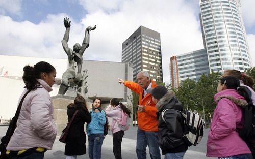 ROTTERDAM – Kinderen van basisschool De Vier Leeuwen bekijken het beeld ”De Verwoeste Stad” van Ossip Zadkine op Plein 1940 in Rotterdam. De kinderen kregen maandagmorgen een rondleiding van Co van Schaik (73), die zelf als 6 jarige het bombardement op de