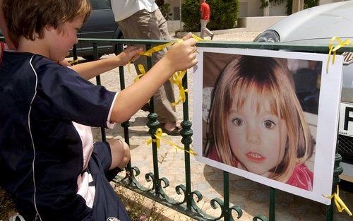 PRAIA DA LUZ - Een Portugese jongen hangt een poster op met het vermiste Britse meisje. Foto EPA