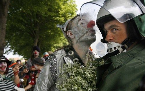 HEILIGENDAMM - Een als clown verklede demonstrant probeert de politie uit de tent te lokken. Duizenden betogers zijn woensdag bij de omheining rond het Noord-Duitse badplaatsje Heiligendamm aangekomen. Het kwam vrijwel onmiddellijk tot botsingen met de po