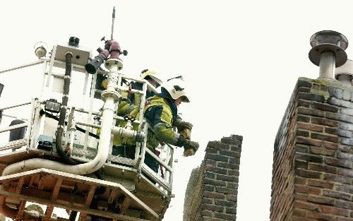 HEERLEN - Brandweerpersoneel breekt een schoorsteen van een huis in Heerlen af. De schoorsteen raakte beschadigd bij de aardbeving die maandag Zuidoost-Nederland trof. - Foto ANP