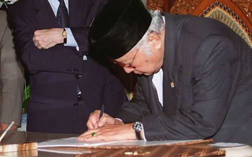 JAKARTA – De Indonesische president Suharto ondertekende begin 1998 een IMF-document waarin zo’n vijftig hervormingen werden geëist om de financiële crisis te boven te komen. IMF directeur Camdessus keek toe. Enkele maanden later moest Suharto onder druk 