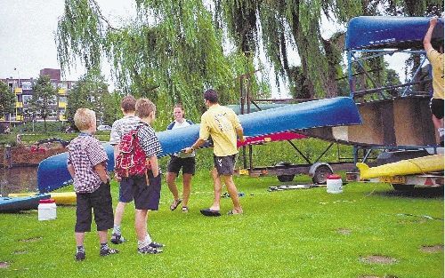 Sanne en een collega van Markant Recreatie uit Doetinchem dragen een kano naar de Oude IJssel. De vaartocht kan -bijna- beginnen. - Foto RD