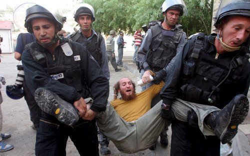 HEBRON – Israëlische agenten dwingen een kolonist hardhandig zijn woning in Hebron op de Westelijke Jordaanoever te verlaten. Foto EPA