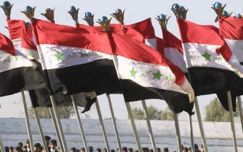 BAGDAD - Leden van een Iraakse militaire jeugdgroep houden de nationale vlag van Irak boven hun hoofden tijdens een zomerkamp in de Iraakse hoofdstad Bagdad. - Foto EPA