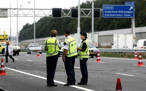 OUDERKERK AAN DE AMSTEL – Politiemensen slaan het verkeer gade dat langzaam weer op gang komt na een ongeluk vrijdag op de A9 bij Ouderkerk. Een overstekende hond veroorzaakte daar een botsing tussen zes auto’s. Twee mensen raakten zwaargewond en er waren