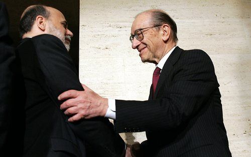 AMSTERDAM – Alan Greenspan (r.) schudt de hand van Ben Bernanke (l.). Bernanke, president van het Amerikaanse stelsel van centrale banken, staat met zijn rug tegen de muur. Dinsdag zal hij naar alle waarschijnlijk heid de rente in de Verenigde Staten verl