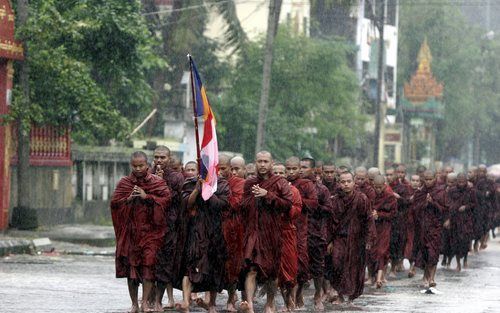 YANGON - Oppositieleidster Aung San Suu Kyi heeft zaterdag bij haar huis in de Birmese hoofdstad Yangon demonstrerende monniken begroet die langs haar huis trokken. Dat meldde de BBC. De monniken protesteren tegen de militaire junta. De demonstratie verli