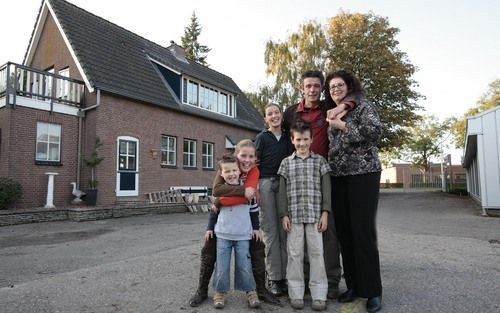 BERGAMBACHT – Cor de Jong en zijn gezin voor hun huis, waar in juni brand uitbrak. Dankzij rookmelders werd hij tijdig gealarmeerd en kon hij samen met zijn vrouw de kinderen redden. Foto Martin Droog