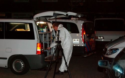 ROTTERDAM - Een politieagent verricht onderzoek in Rotterdam-Zuid waar een 20-jarige man vrijdagavond om het leven kwam. Foto ANP