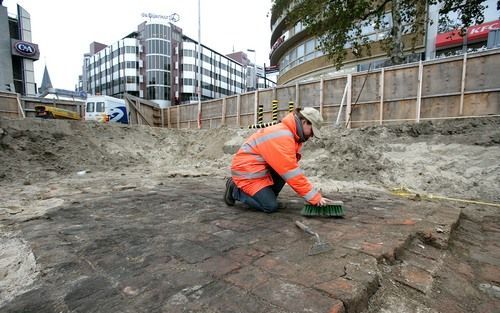 UTRECHT – Archeoloog Kim Spijker veegt op het Utrechtse Vredenburg een tegelvloer schoon. De vloer is met zijn fikse –volgens de archeoloog duidelijk middeleeuwse– steenformaten het eerste zichtbare teken van een middeleeuws woonblok, dat in de 16e eeuw m