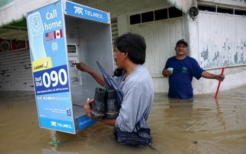 VILLAHERMOSA - Een man voert een telefoongesprek in de ondergelopen hoofdstad van de zuidoostelijke Mexicaanse deelstaat Tabasco. Foto EPA