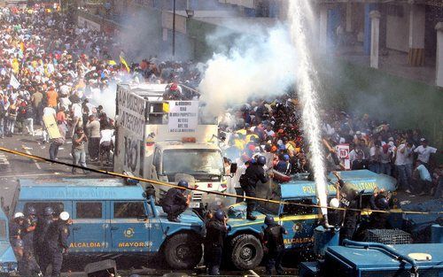 CARACAS – De Venezolaanse oproerpolitie raakte donderdag slaags met demonstrerende studenten in de hoofdstad Caracas. De betogers zijn het niet eens met een serie voorgestelde grondwetswijzigingen die de macht van president Chavez vergroten. Foto EPA