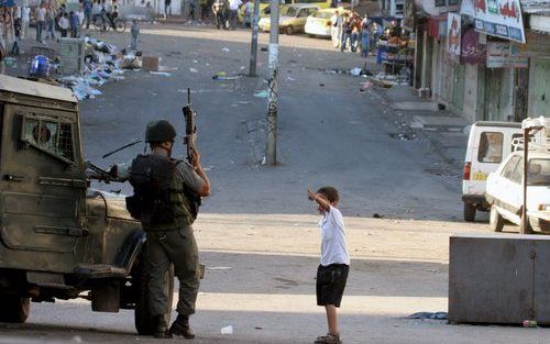 „Dat Israëlische en Palestijnse slachtoffers van het conflict in gelijke mate onschuldig aan hun ellende zijn, is een waarheid die niet aan United Civilians for Peace (UCP) besteed lijkt te zijn.” Foto: Een Palestijns jongetje probeert in Hebron op de Wes