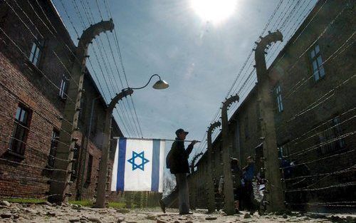 Een jonge Israëli draagt de vlag van Israël tijdens de jaarlijkse ”mars van de levenden” tussen de twee vroegere concentratiekampen Auschwitz en Birkenau, in herinnering aan de slachtoffers van de Holocaust. Foto EPA