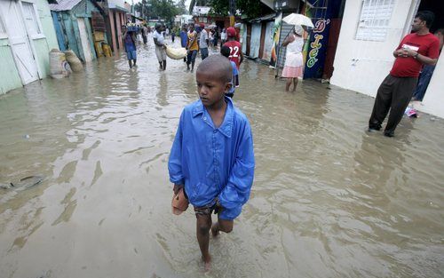 SANTO DOMINGO – Een kind baant zich een weg door de ongelopen straten van een wijk van Santo Domingo, de hoofdstad van de Dominicaanse Republiek. De tropische storm Noël, die vorige week over Santo Domingo raasde, heeft aan zeker 115 mensen het leven geko