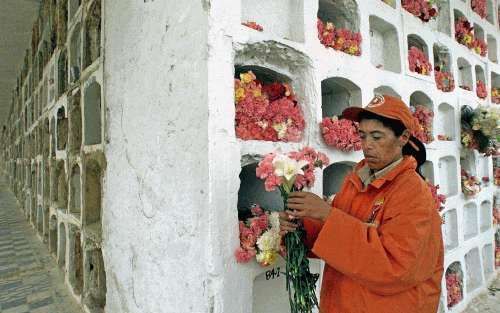 BOGOTA - Een Colombiaanse vrouw loopt langs een gravencomplex in Bogotá waar kinderen begraven liggen die het slachtoffer zijn geworden van de al 37 jaar durende burgeroorlog. - Foto EPA