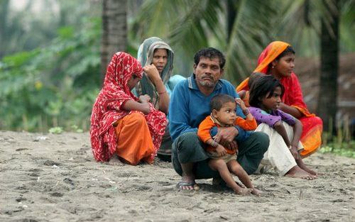 DHAKA - Een Bengalese familie wacht op de kust van Cox's Bazar, Bangladesh, op de komende storm. Foto EPA.