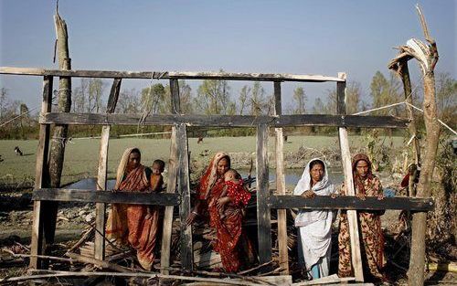 CHAR DUANI - Een Bangalese familie in het dorp Char Duani bij de restanten van hun huis, dat door dat de tropische storm Sidr volledig werd verwoest. Bijna een week nadat de cycloon Bangladesh trof, riep de Bengalese regering de internationale gemeenschap