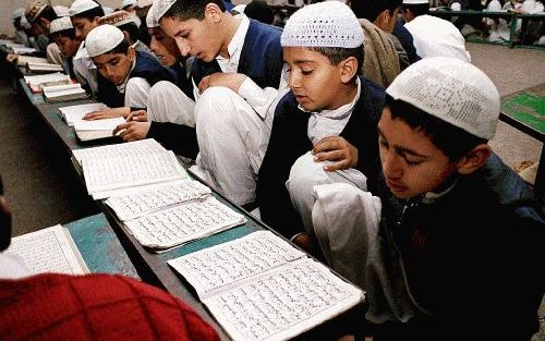 LAHORE - Kinderen lezen aandachtig de koran in een madrassa in Pakistan. - Foto EPA