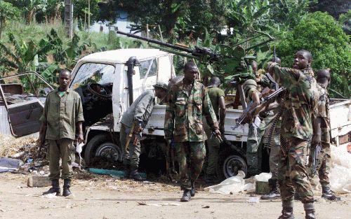 ABIDJAN - Soldaten inspecteren een auto met daarop een groot machinegeweer. In het zakencentrum Abidjan heeft donderdagmorgen urenlang hevig geweervuur geklonken, gemengd met explosies. Volgens een hoge officier en westerse diplomaten is er een opstand va