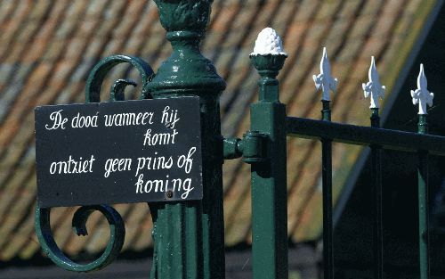 „De dood wanneer hij komt, ontziet geen mens of koning. Hij komt zowel aan ’t hof als aan de boerenwoning.” Deze tekst, op twee geschilderde bordjes, is te lezen op het hek van een boerderij aan de Graafland in Groot-Ammers. - Foto ANP