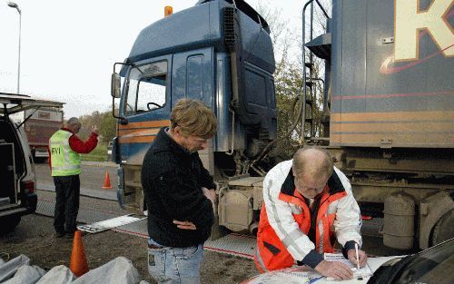 FOXHOL - Een chauffeur parkeert bij het Groningse Foxhol zijn bietenwagen op de mobiele weegbrug. De Inspectie Verkeer en Waterstaat controleert tot en met de Kerst streng op het vervoer van bieten. - Foto Jan Willem van Vliet